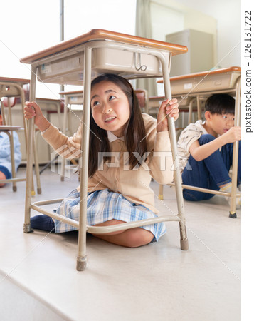 緊急情況下，小學生躲在課桌下 |學校防災防犯模擬影像 126131722