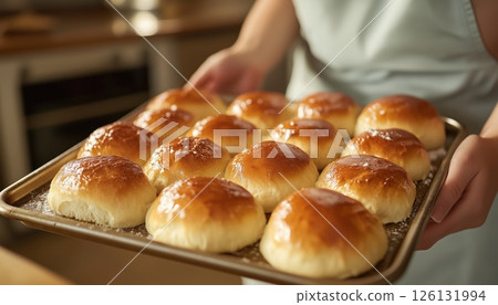 Closeup Of A Woman Removing Baking Tray With Buns From Oven In The Kitchen 126131994