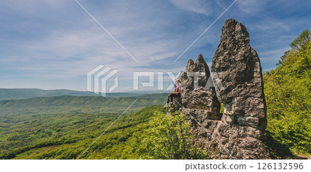 Woman Tourist Sitting on Mountain Rock Woman Tourist Sitting on Mountain Rock 126132596