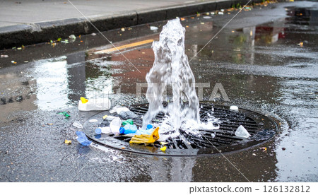 Street drain grate overflowing with plastic waste 126132812