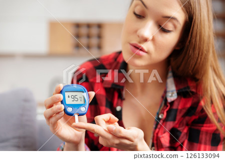 Woman using a glucose monitor. Diabetic disease 126133094