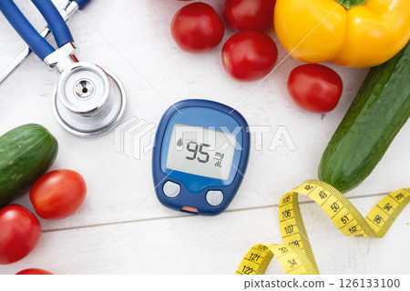 Glucometer and vegetables on desk Glucometer and vegetables on desk 126133100