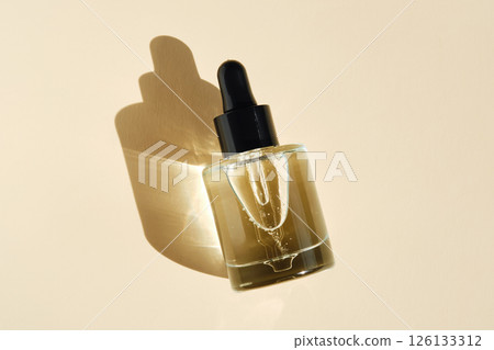 Oily serum with peptides on a beige background. Oily serum with peptides on a beige background. 126133312