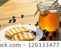 Warm Grilled Pancakes Topped With Syrup and Surrounded by Fresh Blueberries Sit Invitingly on a Plate 126133477