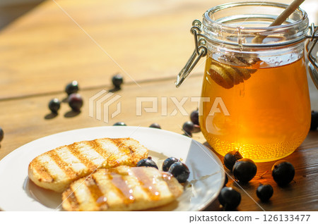 Warm Grilled Pancakes Topped With Syrup and Surrounded by Fresh Blueberries Sit Invitingly on a Plate Warm Grilled Pancakes Topped With Syrup and Surrounded by Fresh Blueberries Sit Invitingly on a Plate 126133477