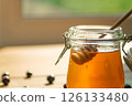 Honey Drips From a Wooden Dipper Into a Glass Jar, Softly Lit ideal for Food Blogs and Wellness Brands 126133480