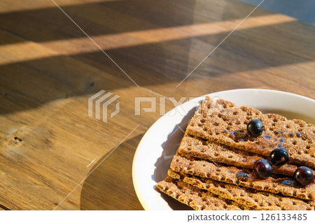 Crispbread Topped With Berries on a Sunlit Wooden Table, Gazing at Vibrant Textures. Concept of Baker, Health Food Store, Cafe 126133485