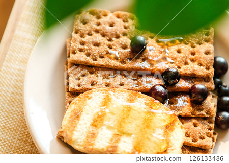 Appetizing Breakfast Platter With Grilled Egg, Crisp Crackers, and Fresh Blueberries on a Rustic Table. Healthy Eating Appetizing Breakfast Platter With Grilled Egg, Crisp Crackers, and Fresh Blueberries on a Rustic Table. Healthy Eating 126133486