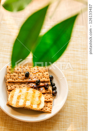 Grilled Bread With Berries and Jam on a Light Table, With Green Leaves in the Background; a Cafe Food Concept 126133487