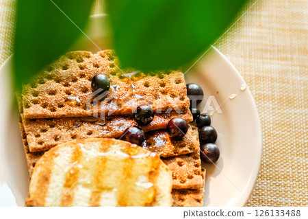 Whole Grain Crackers With Syrup and Blueberries on a Light Table, Highlighting Warmth and Texture for Food Blogs and Recipes Whole Grain Crackers With Syrup and Blueberries on a Light Table, Highlighting Warmth and Texture for Food Blogs and Recipes 126133488