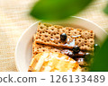 A Breakfast Platter Displays Whole Grain Crackers Drizzled With Honey, Garnished With Fresh Blueberries, Set on a Textured Cloth 126133489