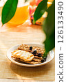 A Plate Holds Crunchy Crackers Topped With Fresh Blueberries, Set in a Vibrant Kitchen Filled With Sunlight and Cheerful Decor 126133490