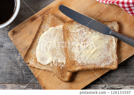 Sliced fresh bread and butter on wooden table Sliced fresh bread and butter on wooden table 126133597