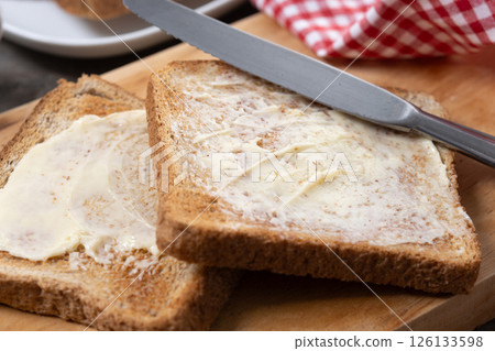 Sliced fresh bread and butter on wooden table Sliced fresh bread and butter on wooden table 126133598