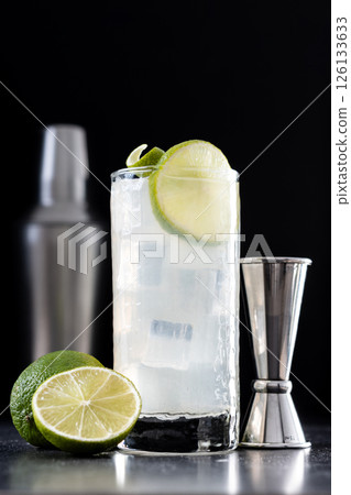 Gin Fizz cocktail with lime on black background 126133633
