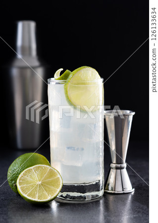 Gin Fizz cocktail with lime on black background Gin Fizz cocktail with lime on black background 126133634