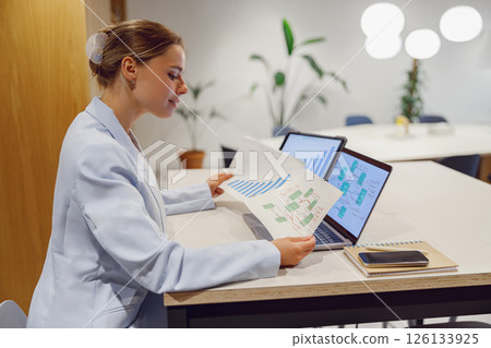 A businesswoman is analyzing key data in a modern office to drive growth and innovation 126133925