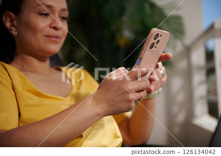 Woman Using Smartphone Outdoors While Relaxing in Bright Daylight 126134042