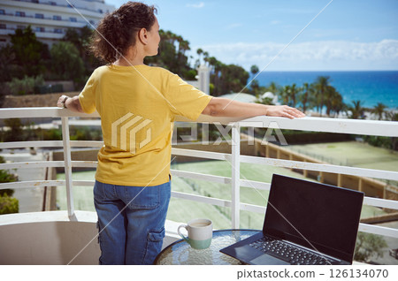 Woman Enjoying Scenic Outdoor View with Laptop on Balcony Woman Enjoying Scenic Outdoor View with Laptop on Balcony 126134070
