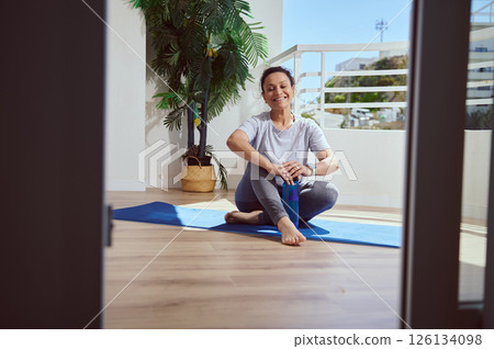 Smiling Woman Relaxing After Yoga Session on Home Patio Smiling Woman Relaxing After Yoga Session on Home Patio 126134098