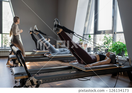 A detailed closeup of a foot work and core exercise on a Balanced Body Reformer machine illuminated by sunlight A detailed closeup of a foot work and core exercise on a Balanced Body Reformer machine illuminated by sunlight 126134173