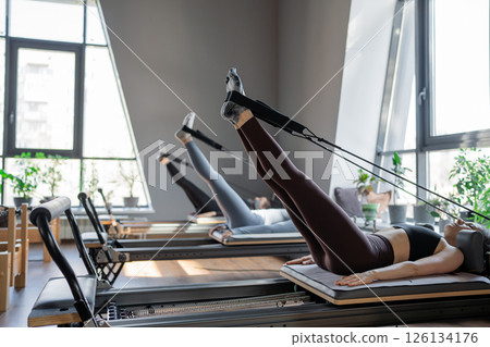 A detailed closeup of a foot work and core exercise on a Balanced Body Reformer machine illuminated by sunlight 126134176