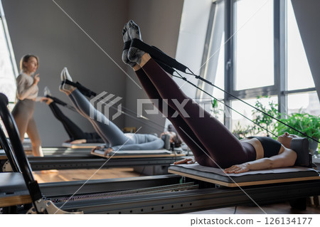 A detailed closeup of a foot work and core exercise on a Balanced Body Reformer machine illuminated by sunlight 126134177