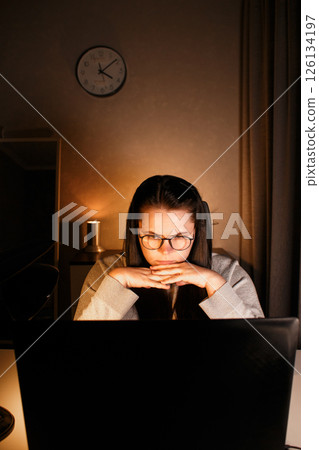Young freelance accountant working remotely on laptop at home. Managing finances of business. Calculating incomes and expenses. Focusing on process. 126134197