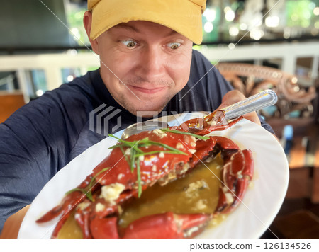 happy man showing crab on plate 126134526