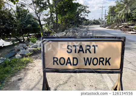 road works start sign with dismantled road surface behind, danger on the road 126134556