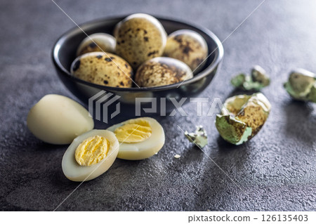 Boiled quail eggs on black table. 126135403