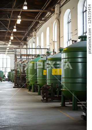 A tapestry of steel and productivity, these tanks seamlessly integrate within the indoor environment, their purposeful presence ensuring efficient manufacturing. 126135454