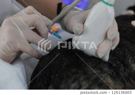 A veterinarian wearing gloves using an ultrasound scanner while performing a biopsy on a dog at a veterinary clinic. Performing a diagnostic procedure to accurately diagnose and treat a dog. 126136805