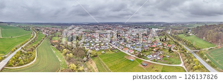Aerial view of Bad Arolsen with residential area, fields and forest under cloudy sky 126137826