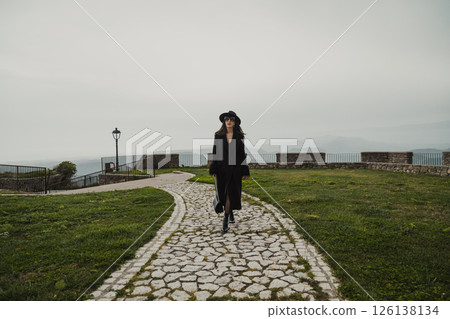 Woman Walking On The Stone Path On The Square Near The Castle 126138134