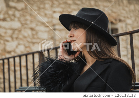 Elegant Black Dressed Woman On The Town Bench Having A Fun Call Close Up 126138138
