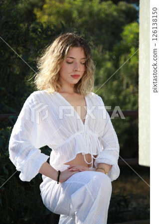 Young Woman in White Dress Performs Dance Moves by a Railing 126138150