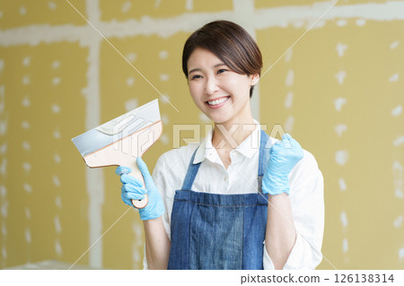一位女士正在自己動手為石膏板塗膩子 126138314