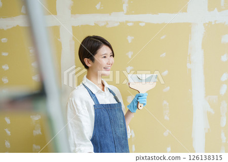一位女士正在自己動手為石膏板塗膩子 126138315