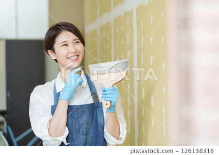 一位女士正在自己動手為石膏板塗膩子 126138316