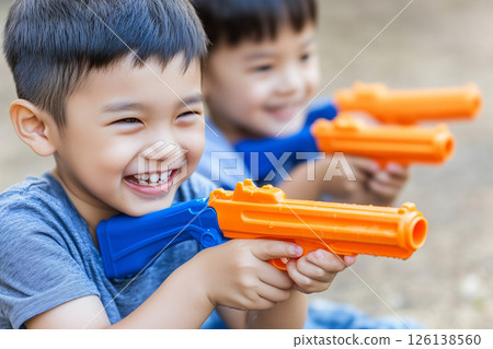 Joyful Children Enjoying Water Gun Play During Songkran Festival Celebrations in Thailand 126138560