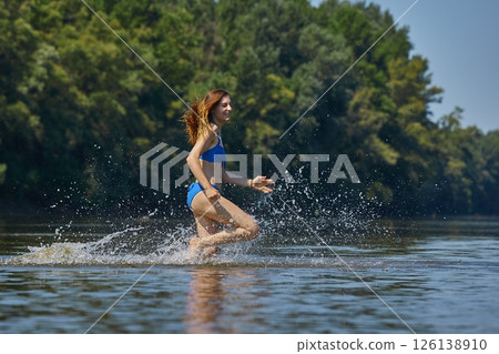 Girl at the beach running into the water Girl at the beach running into the water 126138910