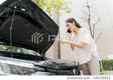 A woman in trouble because her car broke down 126138913