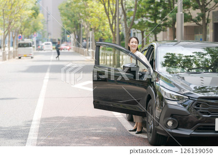 站立在汽車前面的一個少婦 站立在汽車前面的一個少婦 126139050