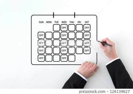 The hand of a man in a suit drawing a calendar reflecting the three-day work week system 126139627