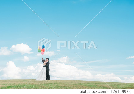 Bride and groom with sky as background (wedding, wedding ceremony, bridal, balloon release, photo wedding) Bride and groom with sky as background (wedding, wedding ceremony, bridal, balloon release, photo wedding) 126139924
