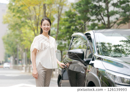一位年輕的女士從車上下來 126139993