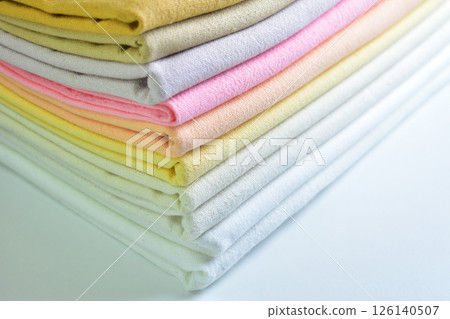 stack of colourful cotton clothes, pile of clothing on white background 126140507