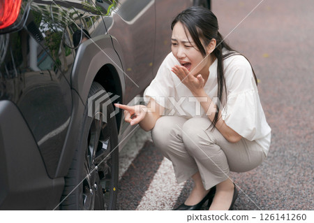 檢查輪胎故障的年輕女子 126141260