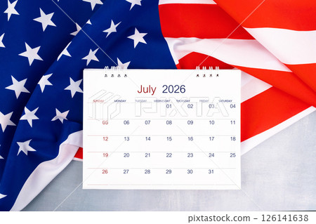 July 2026 desk calendar and United States of America flag on table, Flat lay. 126141638